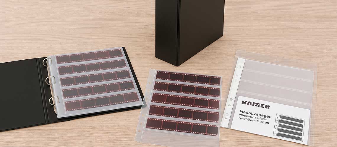 Kaiser archival storage system with negative sleeves and binders neatly organised on a table.