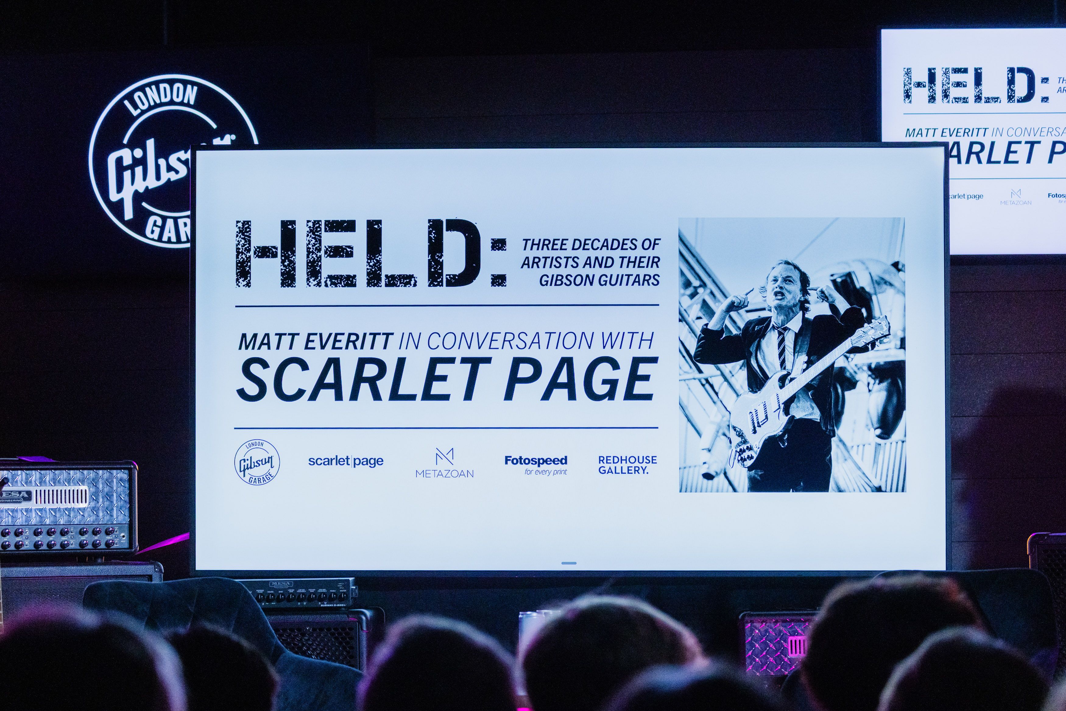 HELD exhibition screen at the event with an audience seated at Gibson Garage London