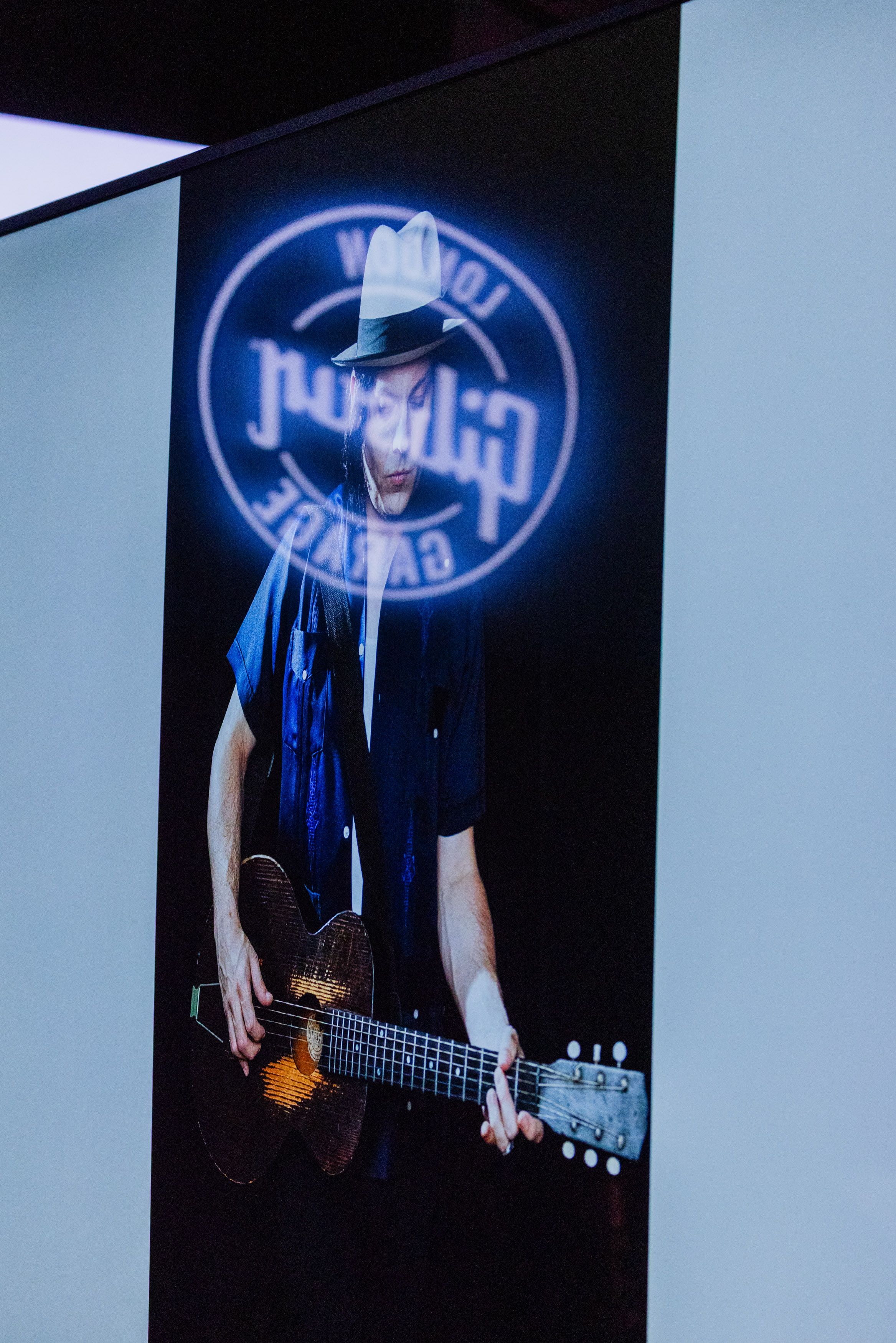 A large exhibition photograph of a guitarist displayed inside Gibson Garage London